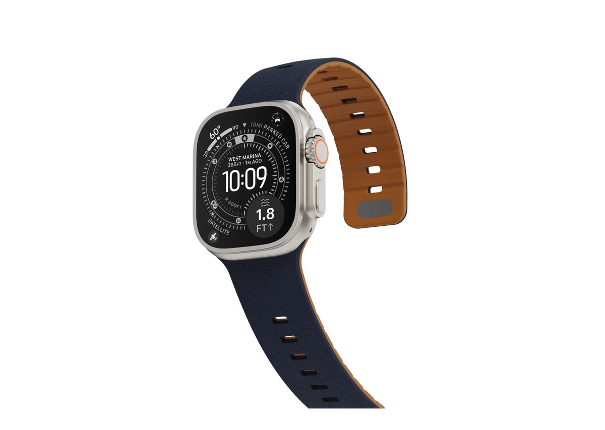 Apple Watch Ultra fitted with a navy blue textured silicone strap, showing the contrasting brown inner surface and adjustable magnetic closure